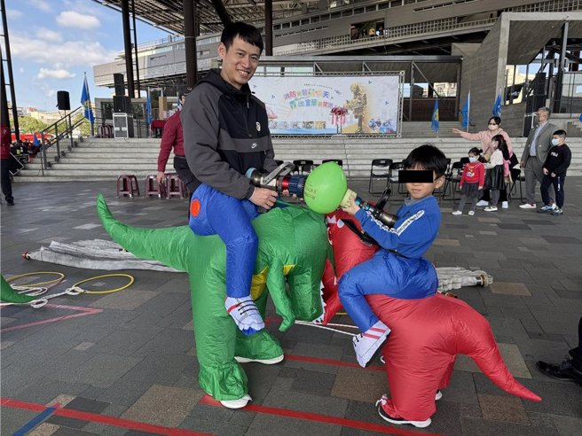 让孩子们化身为小小消防员和亲子穿恐龙装挑战水带布线、体验无人机等项目。（吴佩蓉摄）