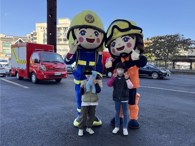 安排两只可爱的消防大头公仔与民眾亲切互动拍照，为小小朋友带来欢乐回忆。（吴佩蓉摄）