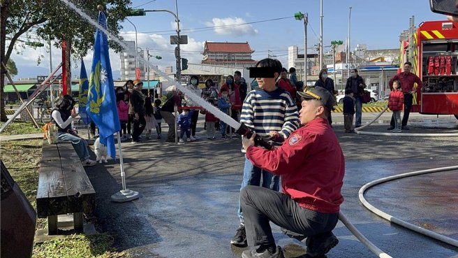 让孩子们化身为小小消防员和亲子穿恐龙装挑战水带布线、体验无人机等项目。（吴佩蓉摄）