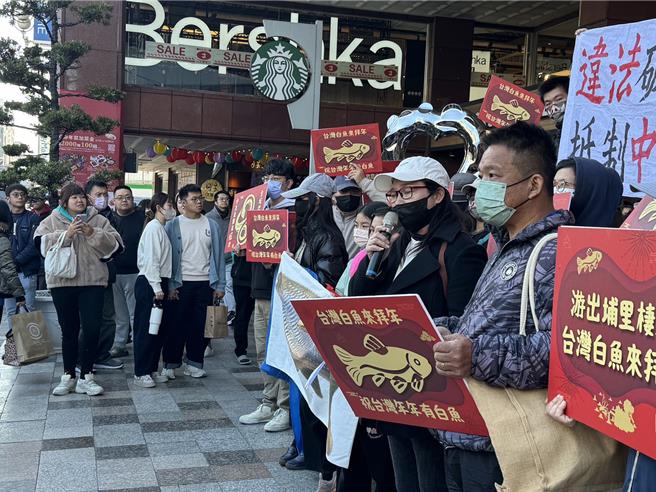 森形埔里农庄旅馆渡假村开发案遭在地居民反对，约20人12日再度到中友百货「踩街拜年」，控诉开发案违法破坏山林，威胁在地水源及台湾白鱼栖地，路过民眾停下脚步关注。（潘虹恩摄）