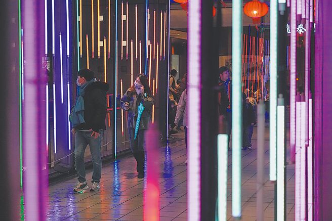 电费是否再调涨？由于立法院还未同意拨补，将对台电财务有很大的影响，如果最后没有拨补，台电就必须举债。图为民眾经过装满霓虹灯的天桥。（罗永铭摄）