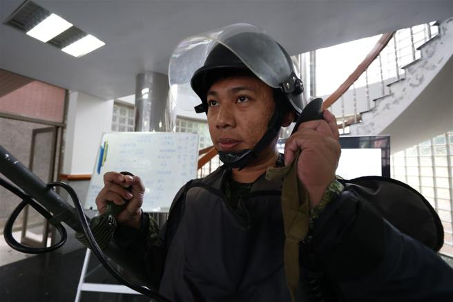  操作人员须先卸下全身的金属物，包含戒指、项炼，确保金属探测功能运作正常。（记者袁铭骏摄） 