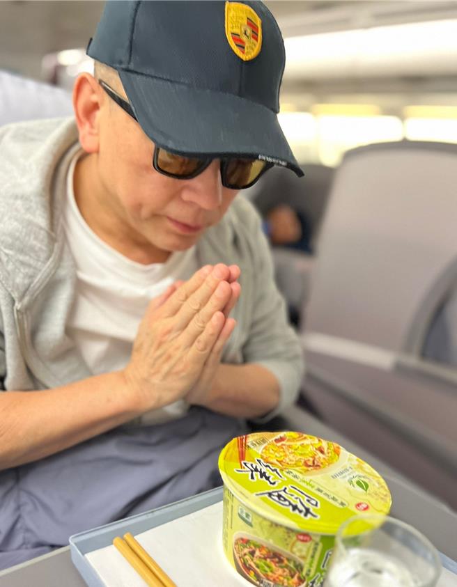 詹唯中在飞机上双手合十祈福。（詹唯中提供）