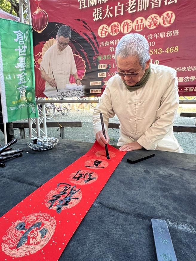 由张太白老师带领学员们在罗东中山公园挥亳义卖春联。（创世基金会罗东院提供／吴佩蓉宜兰传真）