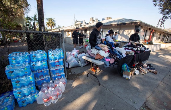 善心团体募集衣物和其他物资，分发给因火灾而失去一切的受灾户。(图/路透社)