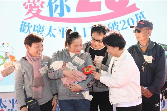 太平區公所14日在馬卡龍公園舉辦人口突破20萬慶祝活動，第20萬人往前推算前6名新生兒頒贈幸福好禮，其中最接近第20萬人的新生兒楊小妹，更可獲得2錢黃金鎖片。（馮惠宜攝）