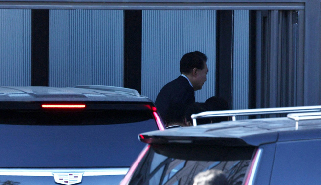 南韩总统尹锡悦15日上午被捕后，车队前往公调处办公室，他也被捕捉到走下座车、走进公调处大楼准备接受调查的画面。（路透社）