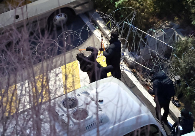 警方为执行对遭弹劾的南韩总统尹锡悦的逮捕令，正在切割设置于官邸入口的铁丝网。（图／路透）