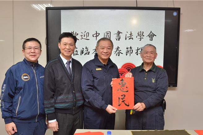 中国书法学会理事邱坤生（右一）现场书写「惠民」。（新北市警察局提供）