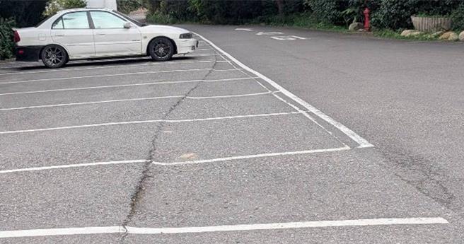 桃园市新屋区滨海路永安段251巷内的停车格与柏油路面，疑似因周边工程多重车出入频繁，导致路面严重变形，产生约5公分的高低落差，民眾忧成隐患。（陈睿生提供／廖姮玥）