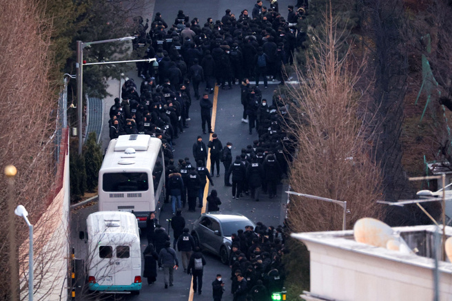 南韩公调处及警方15日只花费30分钟，就通过3道防线、直捣尹锡悦官邸建筑，期间未受到阻挡。图为公调处及警方15日上午通过防线，进入总统官邸园区。（路透社）