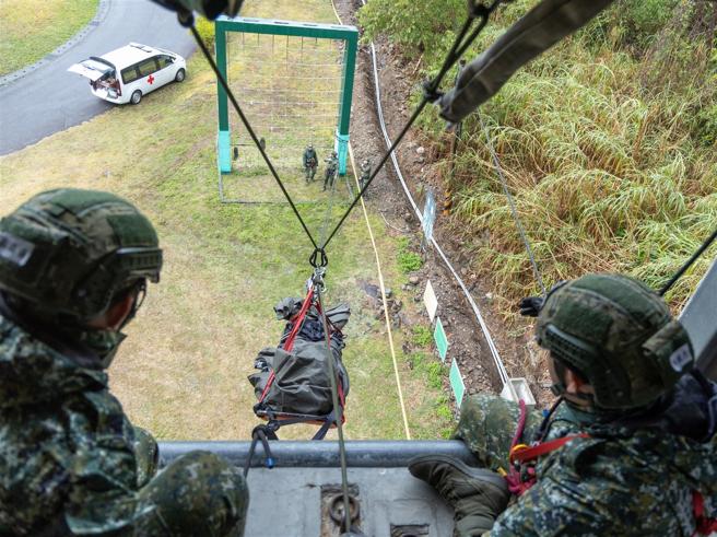 在「V型拖拉」部分，由学员使用紧绷绳架设技巧，将担架稳定的从滞空塔往地面运送。
（记者尤韵婷摄）