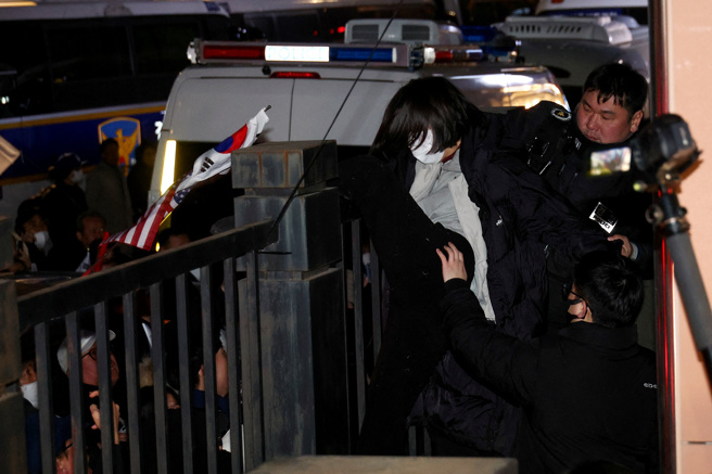 南韩总统尹锡悦19日凌晨遭裁定羁押，大批支持者于当地时间凌晨3时过后闯进法院，任意破坏法院窗户及家具并高喊法官。图为18日尹锡悦支持者在法院外示威。（路透社）