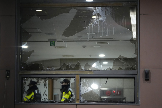 画面为遭尹锡悦支持者破坏的首尔西区地方法院，19日清晨警方平息暴动后，员警在法院内巡逻。（美联社）