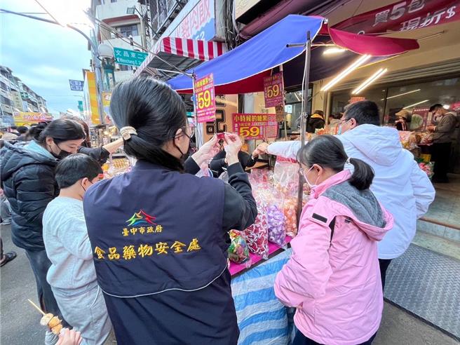 台中食安處稽查員到天津商圈年貨大街，查獲逾期糖果，現場責令業者下架。（台中市食安處提供／馮惠宜台中傳真）