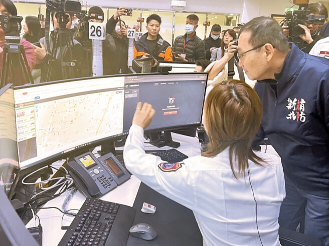 新北市长侯友宜（右）18日视察消防局首创「安心简讯4.0」智能视讯报案系统，救灾救护指挥中心模拟受理报案，侯友宜仔细观看。（王扬杰摄）