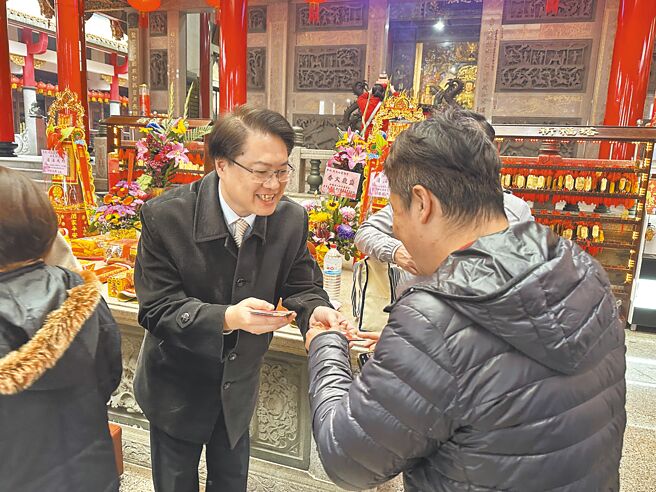 民进党秘书长林右昌（左）19日代表民进党主席赖清德到汐止区4间庙宇参香、发放春联与1元红包。（高钧麟摄）
