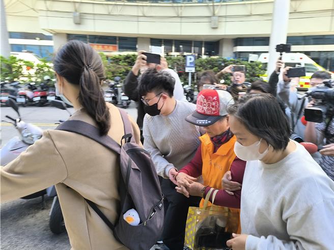 胡母（戴帽者）在家属搀扶下前往医院认尸。（李京升摄）