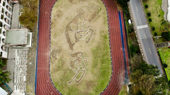 淡水新兴国小工友在操场草皮刻台湾尚勇巨作，引起热烈回响。（图／取自蔡其昌Threads）