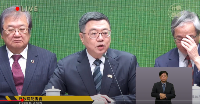 行政院长卓荣泰今（23日）第四度亲上火线，率部会首长召开记者会说明总预算。不过行政院此次直接在字幕打上「本院新传处费用遭在野党全数删除，无法聘用手语老师」的字样。（取自行政院开麦啦YT频道）