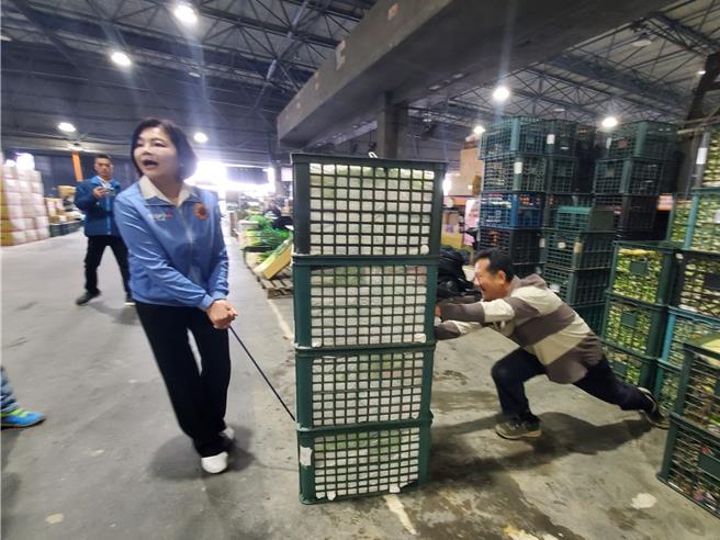 雲林縣長張麗善（左）今天視察西螺果菜市場，她嘗試拖菜，菜商偷偷幫她推一把。（周麗蘭攝）