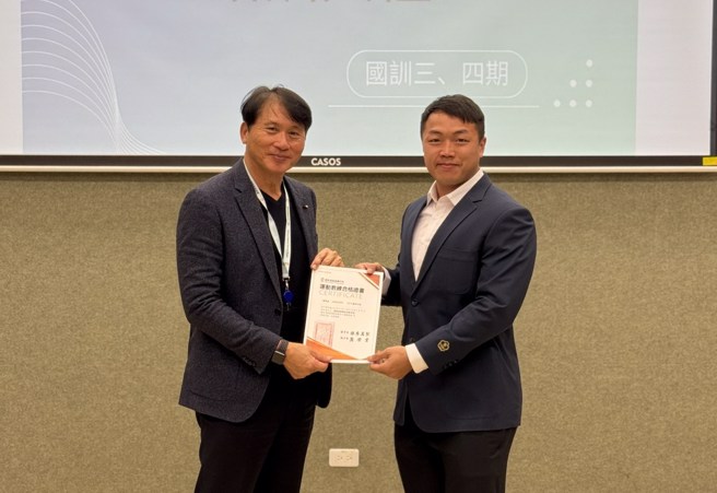 國訓中心執行長龔榮堂(左)頒發合格證書給橄欖球運動教練謝秉益。(國訓中心提供)