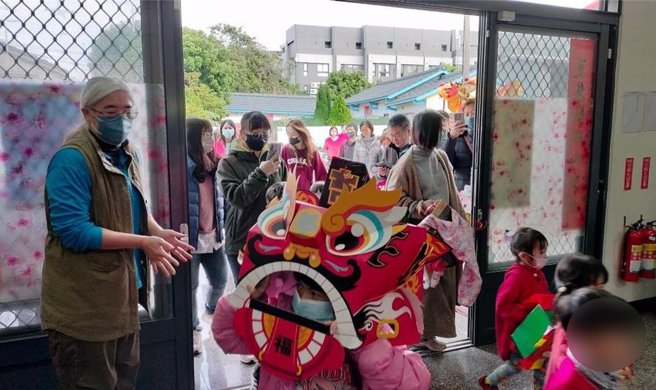 台中市龙井幼儿园龙岗班幼童在师长陪同下，步行穿梭在社区进行「舞龙舞狮贺新年快闪活动」。（民眾提供／冯惠宜台中传真）