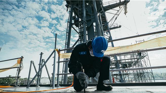 舰体除锈作业过程中，官兵敲击目标区域确认锈蚀是否影响周围结构。（军闻社提供）