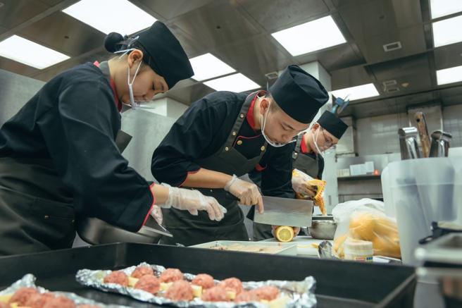 官兵施展精湛厨艺，制作一道道美味佳肴。（记者陈怡璇摄）