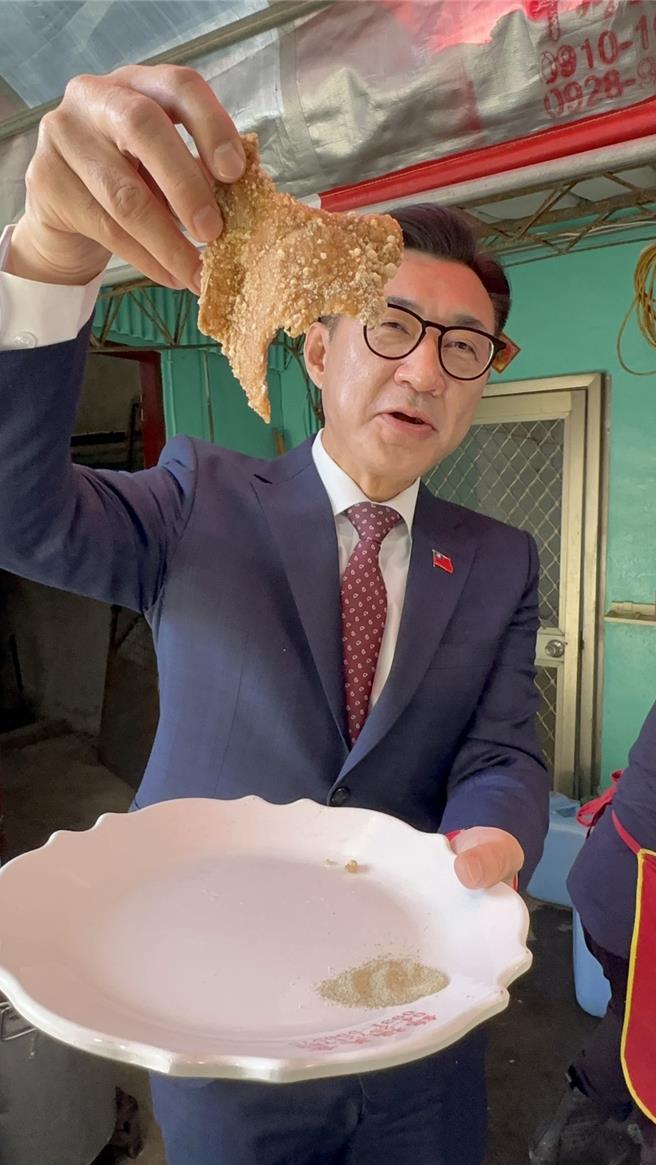 立法院副院長江啟臣享用剛起鍋的現炸肉排，直呼「這就是過年的味道！」。（江啟臣服務處提供／葉靜美台中傳真）
