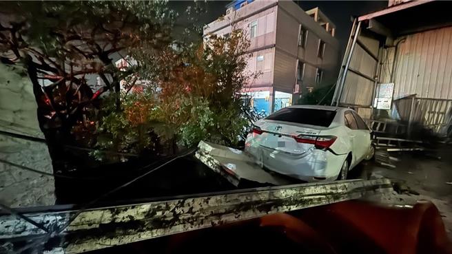 一輛白色轎車1日清晨5時許撞進高雄市大寮區一處工廠大門及圍牆，駕駛肇事後逃逸。（民眾提供／郭良傑高雄傳真）