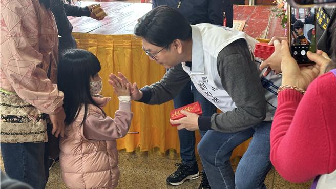 劉和然也在各宮廟發放小紅包，吸引大批民眾前來領取祝福討吉祥。（賀培晏攝）