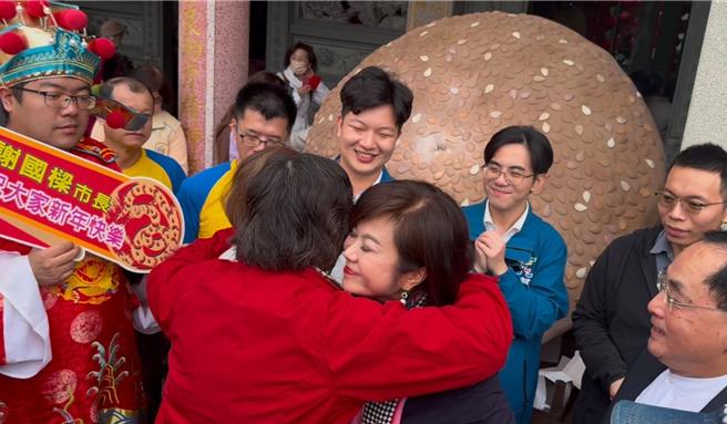前民眾党立委蔡壁如参选民眾党主席，1日至基隆城隍庙「巧遇」基隆市副市长邱佩琳发放红包活动，邱佩琳大方与蔡壁如拥抱祝福，一同发放红包给市民。（徐佑升摄）