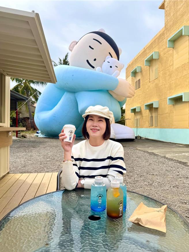 屏东县长周春米到看海美术馆「落山风艺术季」，在海口村与巨型软雕塑「女孩与猫」喝咖啡，美拍羡煞许多人。（翻摄周春米脸书／谢佳潾屏东传真）