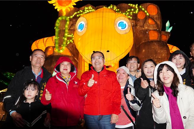 新北市长侯友宜（中）1日晚间出席「2025新北灯会」活动开幕仪式，并与民眾在12米巨型主灯「灵蛇献瑞」前合影。（张铠乙摄）