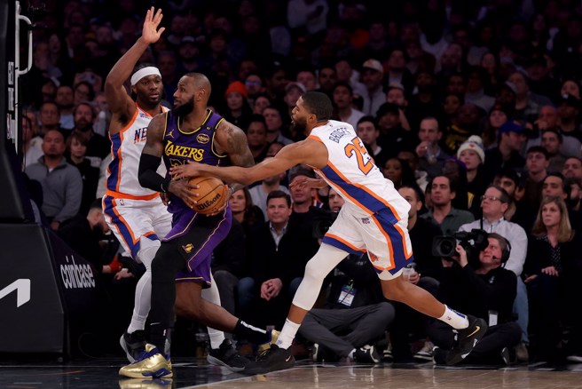 眼見擋不住詹姆斯持球切入，布瑞吉斯(右)只能從後撈球。(路透)