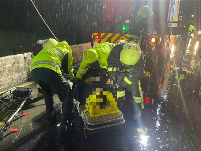 简姓男子自撞护栏，跌落铁轨旁，消防人员以吊挂方式救援。（新北市消防局提供）