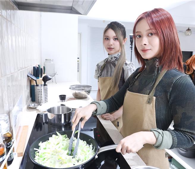 XXIN（右）負責拌炒洋蔥、高麗菜，炒熟後再加入鮪魚罐頭，左為許媛媛。（陳俊吉攝）