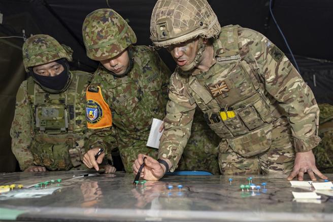 　英军（右）与自卫队员检视地图，讨论任务规划。（取自英国国防部网站）