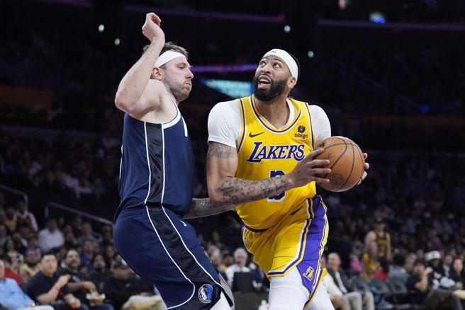 独行侠东契奇(左)防守湖人戴维斯。（美联社资料照）