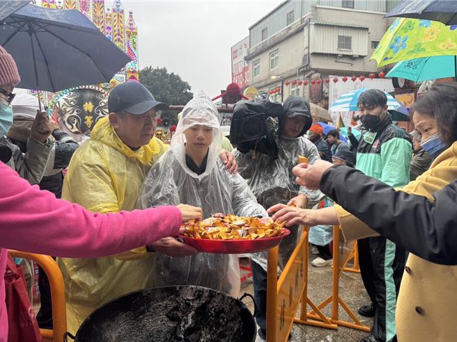 新北市三峡赛神猪祭今（3）日在三峡祖师庙登场，祭拜完神猪后，现场分发糖果让民眾沾喜气。（柯毓庭摄）