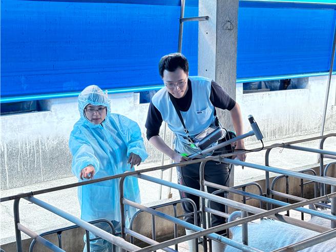 高市青年局副局長汪小芬（左）身穿防護衣，體驗母豬「超音波測孕機」操作。（圖／高市府青年局）
