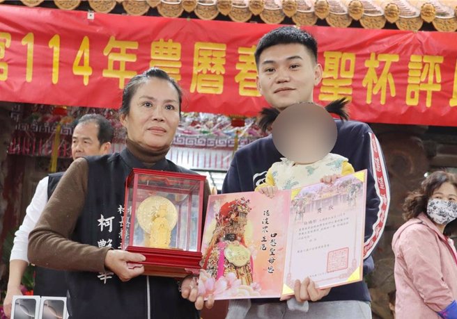 刚满1岁的白姓女童在家人协助下一口气连掷出13个圣筊，成功请回金妈祖。（吕妍庭摄）