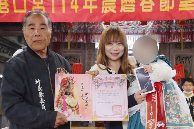 1岁多赖姓女童在大年初三掷出12圣筊，喜获iPhone 16 Pro。（吕妍庭摄）