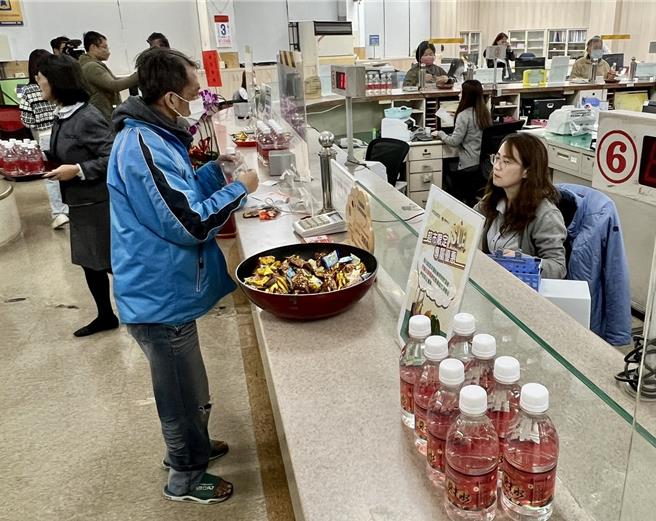 草屯镇农会开工日将睡在金库9天吸满财气的发财水与客户分享，祝福客户财运亨通。（杨静茹摄）