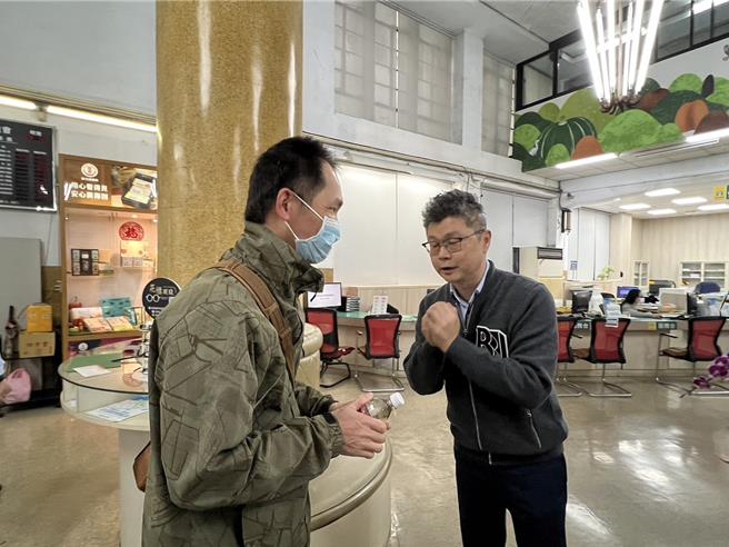 草屯镇农会总干事简世泓在开工日在信用部发放发财水，感谢客户长期的支持，并送上祝福。（杨静茹摄）