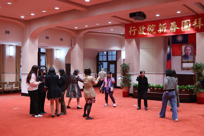 114年新春团拜」，整个会场空荡荡，只挂着简单的「行政院新春团拜」的布条。会后行政院同仁在会场拍照留念。（邓博仁摄）