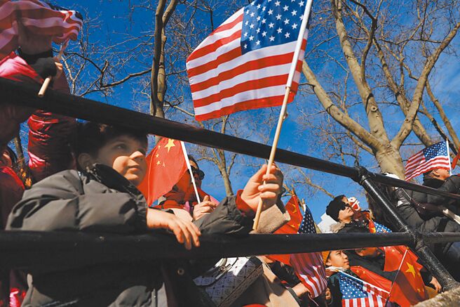 美国对大陆加徵10%关税，恐将导致其国内通膨压力。图为美国纽约市曼哈顿唐人街，人们挥舞着美国和中国国旗，参加农历新年庆祝活动。（路透）