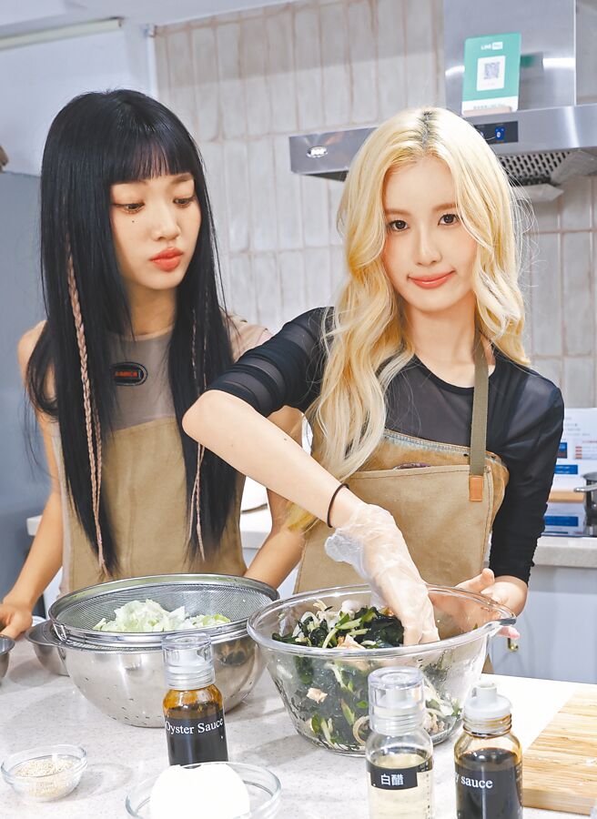 毓（右）把煮好的雞胸肉和海帶拌勻，采甄在旁見習。（陳俊吉攝）