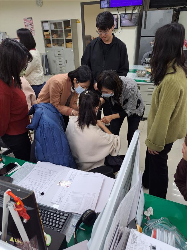 妇幼队警员曾英绫冲泡奶粉喂食飢肠辘辘的新生儿，热心同仁在旁协助。（台中市警察局提供）